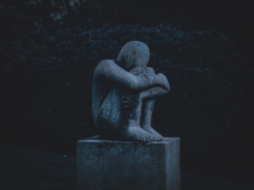 statue of someone sitting curled up