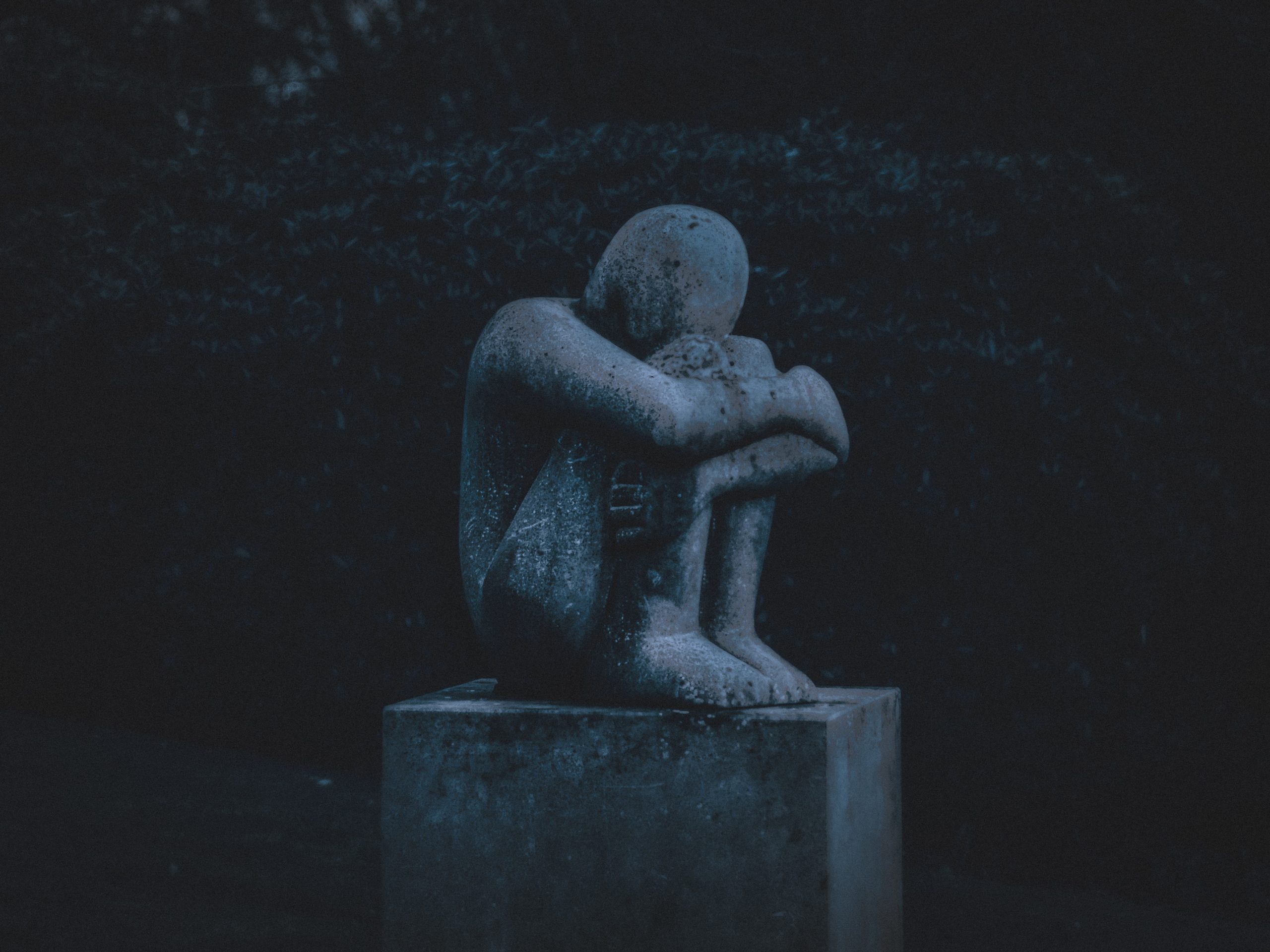 statue of someone sitting curled up